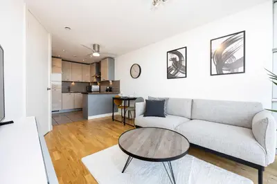 a living room with a couch and a table at Stunning Skyline Liverpool Apartment with Parking in Liverpool