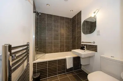 a bathroom with a tub and a sink and a toilet at Stunning Skyline Liverpool Apartment with Parking in Liverpool