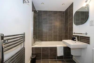 a bathroom with a bath tub and a sink at Stunning Skyline Liverpool Apartment with Parking in Liverpool