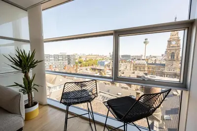two chairs in a room with a view of a city at Stunning Skyline Liverpool Apartment with Parking in Liverpool