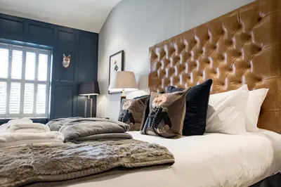 a bedroom with a large bed with a large headboard at Freemasons at Wiswell in Whalley