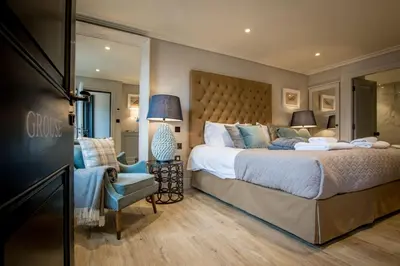 a bedroom with a large bed and a chair at Freemasons at Wiswell in Whalley