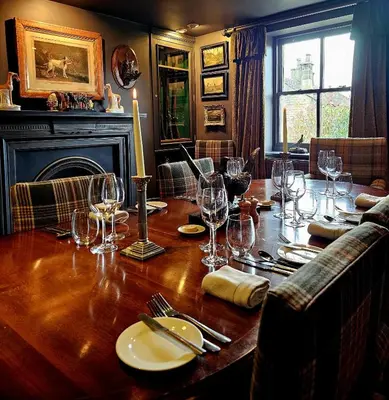 a wooden table with wine glasses on top of it at Freemasons at Wiswell in Whalley