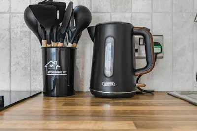 two utensils in a black container on a kitchen counter at GuestReady - Stylish Flat with Bay View in Liverpool