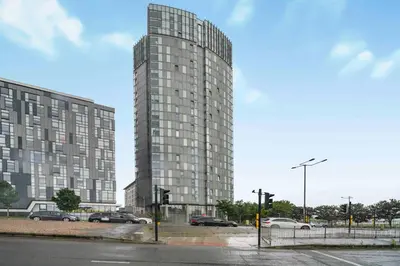 a tall building with cars parked in a parking lot at GuestReady - Stylish Flat with Bay View in Liverpool