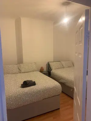 a bedroom with two beds and a hat on the bed at Spacious, Modern 4BR House, LFC, Free Parking in Liverpool