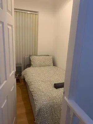 a small bedroom with a bed in a room at Spacious, Modern 4BR House, LFC, Free Parking in Liverpool