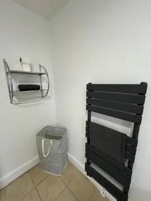 a bathroom with a black towel rack and a basket at Spacious, Modern 4BR House, LFC, Free Parking in Liverpool
