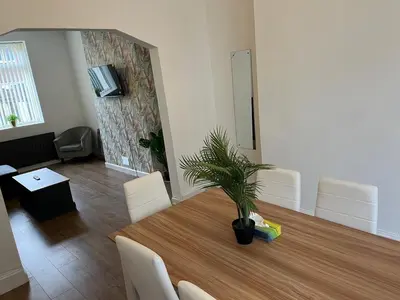 a dining room with a table with a plant on it at Spacious, Modern 4BR House, LFC, Free Parking in Liverpool