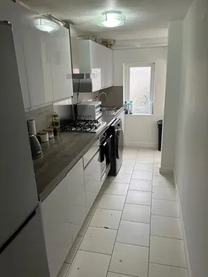 a kitchen with white cabinets and a tile floor at Spacious, Modern 4BR House, LFC, Free Parking in Liverpool