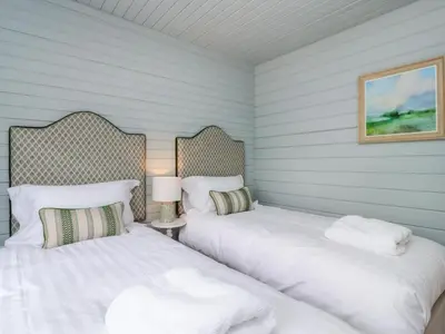 two beds in a room with blue walls at Manor Lodge in Clitheroe
