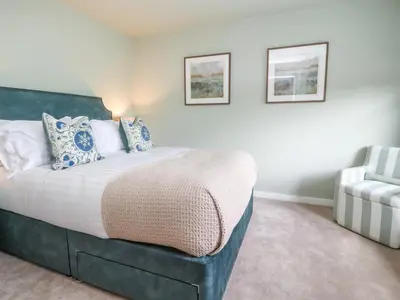 a bedroom with a bed and a chair at Manor Lodge in Clitheroe