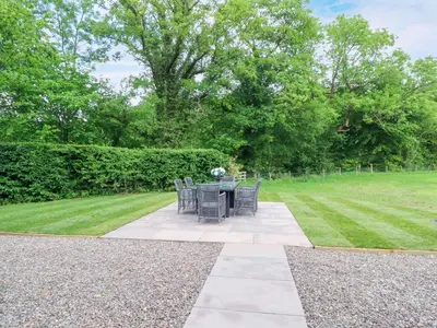 a patio with a table and chairs in a garden at Manor Lodge in Clitheroe