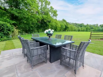 a black table with chairs and a vase of flowers on it at Manor Lodge in Clitheroe