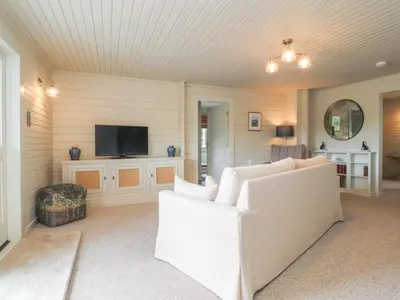 a living room with a couch and a tv at Manor Lodge in Clitheroe