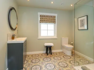 a bathroom with a toilet and a sink and a window at Manor Lodge in Clitheroe