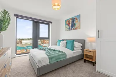 a bedroom with a bed and a large window at Verona Apartment - City Apartment - 2Bed 2Bath in Liverpool