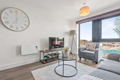a living room with a large clock on the wall at Verona Apartment - City Apartment - 2Bed 2Bath in Liverpool