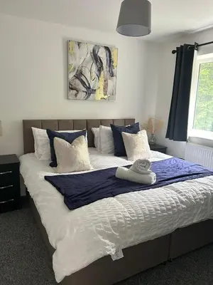 a bedroom with a large bed with blue and white pillows at Spacious 4BR House with Backyard in Saint Helens in Saint Helens