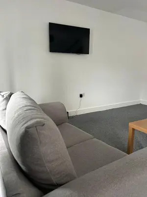 a living room with a couch and a flat screen tv at Spacious 4BR House with Backyard in Saint Helens in Saint Helens