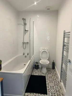 a bathroom with a tub and a toilet and a shower at Spacious 4BR House with Backyard in Saint Helens in Saint Helens