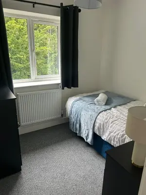 a bedroom with a bed and two windows at Spacious 4BR House with Backyard in Saint Helens in Saint Helens