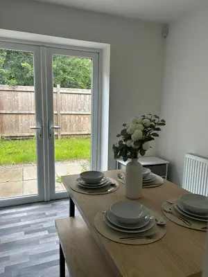 a dining room table with plates and a vase of flowers at Spacious 4BR House with Backyard in Saint Helens in Saint Helens