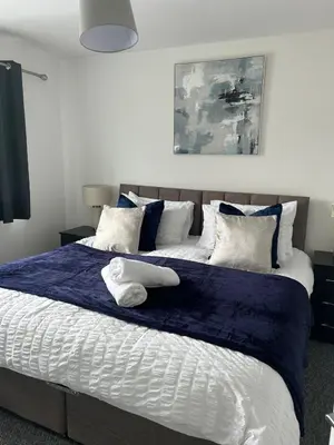 a bedroom with a large bed with a blue blanket at Spacious 4BR House with Backyard in Saint Helens in Saint Helens