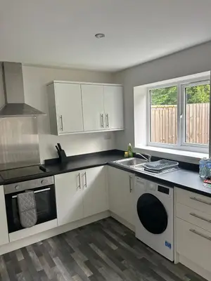 a kitchen with white cabinets and a sink and a stove at Spacious 4BR House with Backyard in Saint Helens in Saint Helens