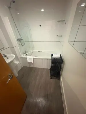 a bathroom with a bath tub and a sink at Large city centre apartment in Liverpool