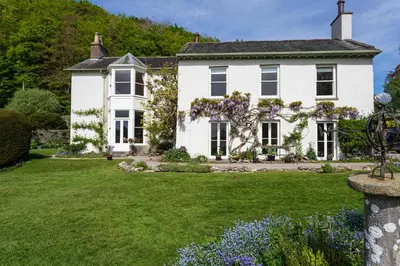 a white house with a green yard at Haverbrack Country House in Beetham