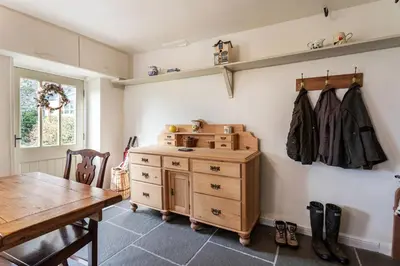 a dining room with a wooden dresser and a table at Haverbrack Country House in Beetham