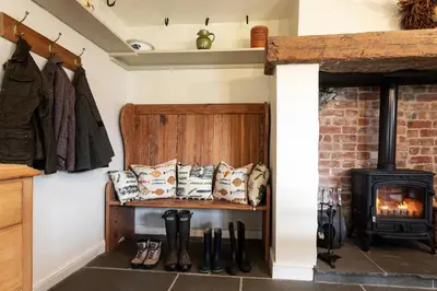 a living room with a fireplace and a stove at Haverbrack Country House in Beetham