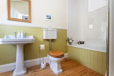 a bathroom with a toilet and a sink and a tub at Haverbrack Country House in Beetham