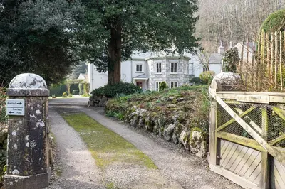 a gate leading to a house with a driveway at Haverbrack Country House in Beetham