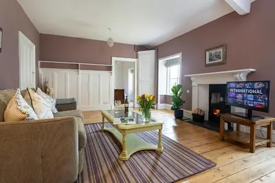 a living room with a couch and a tv at Haverbrack Country House in Beetham