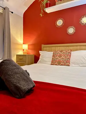 a bedroom with a bed with a red wall at Luxury 4 Bed Home Sleeps 9, Games Room, Parking