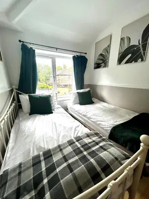 two beds in a room with a window at Luxury 4 Bed Home Sleeps 9, Games Room, Parking