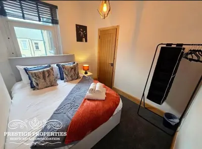 a bedroom with a bed with a large window at 12 Romney Road by Prestige Properties SA in Barrow in Furness