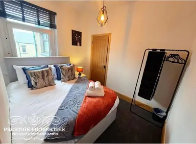 a bedroom with a bed and a television in it at 12 Romney Road by Prestige Properties SA in Barrow in Furness