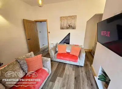 a living room with a couch and a tv at 12 Romney Road by Prestige Properties SA in Barrow in Furness