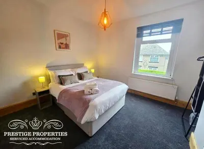 a bedroom with a large bed and a window at 12 Romney Road by Prestige Properties SA in Barrow in Furness