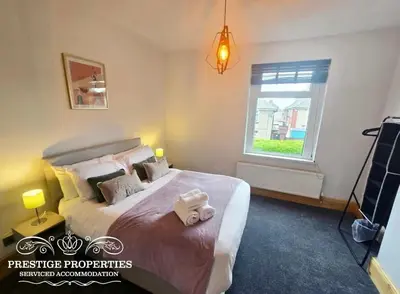a bedroom with a bed with two towels on it at 12 Romney Road by Prestige Properties SA in Barrow in Furness