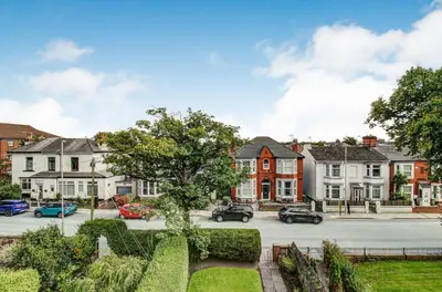 a street with houses and cars parked in a town at Quaint Studio Apartment Near To Waterfront in Wallasey