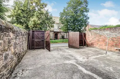 an old brick building with a gate and a brick wall at Quaint Studio Apartment Near To Waterfront in Wallasey