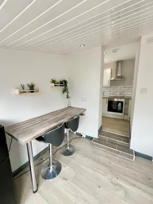 a kitchen with a wooden table and two chairs at Cosy Bungalow & Peaceful Garden in Halsall