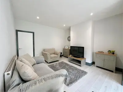 a living room with a couch and a television at Cosy Bungalow & Peaceful Garden in Halsall