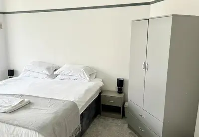a bedroom with a bed and a white cabinet at Cosy Bungalow & Peaceful Garden in Halsall