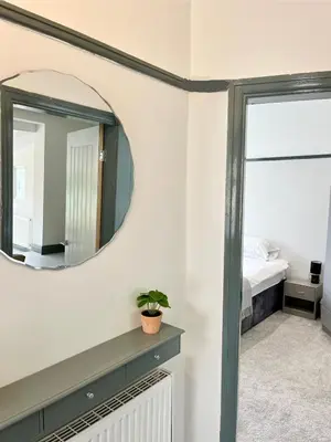 a bedroom with a mirror and a bed at Cosy Bungalow & Peaceful Garden in Halsall