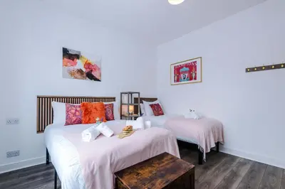 two beds in a room with white walls at Stunning & Spacious Home by 53 Degrees Property, Sleeps 7 in the heart of Anfield! in Liverpool